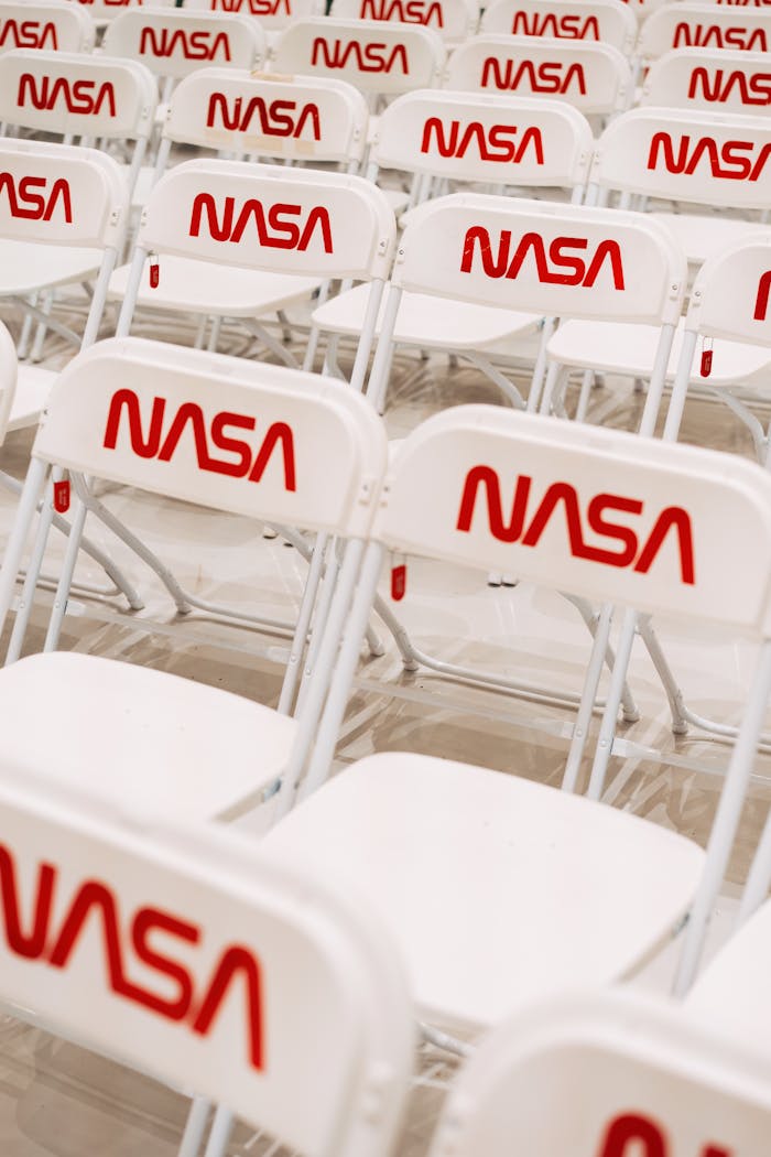 Rows of white chairs with NASA logo setup for indoor event seating.
